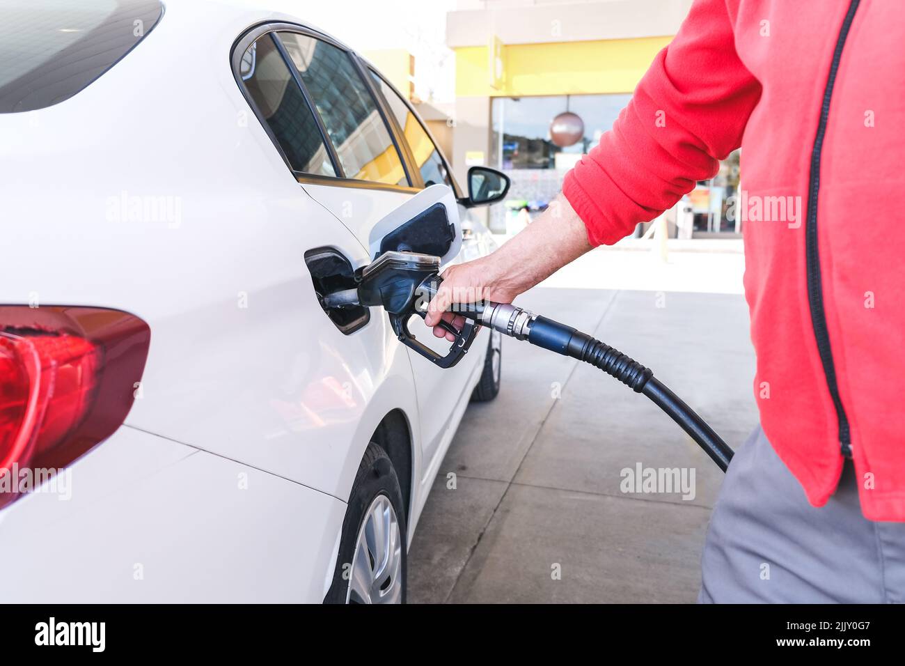 Pumping gas at gas pump. Closeup of man pumping gasoline fuel in car at