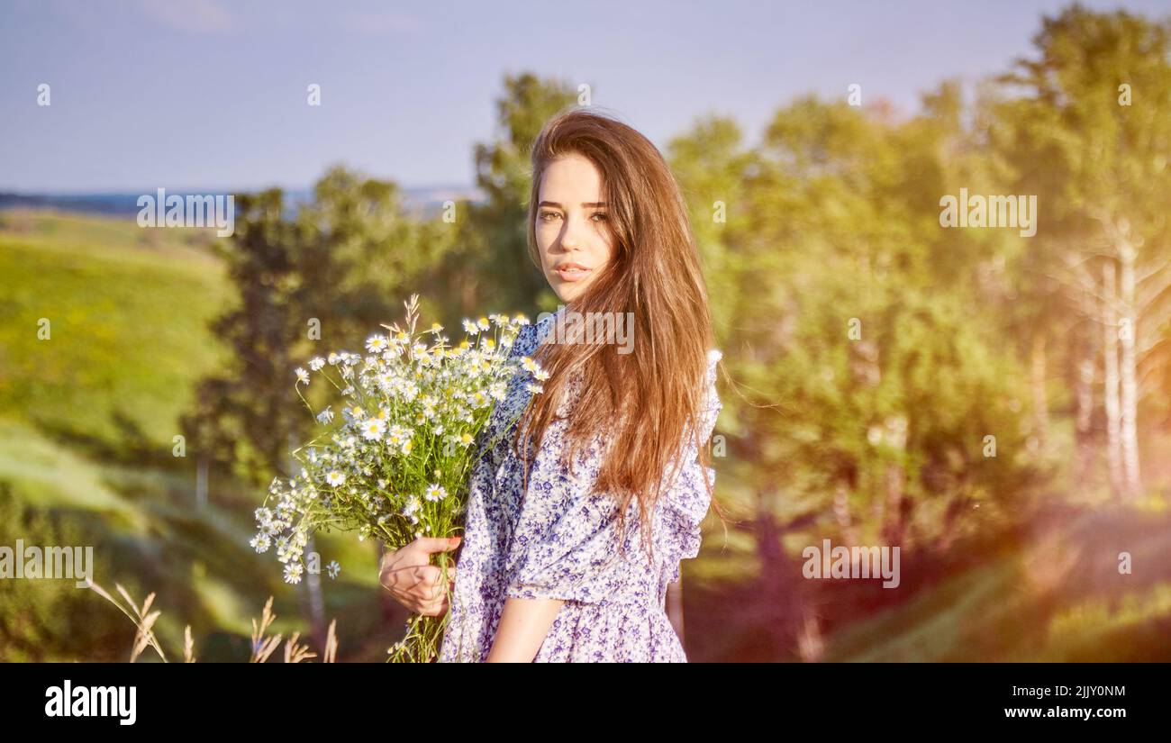 young beautiful girl with a bouquet of flowers in nature Stock Photo ...
