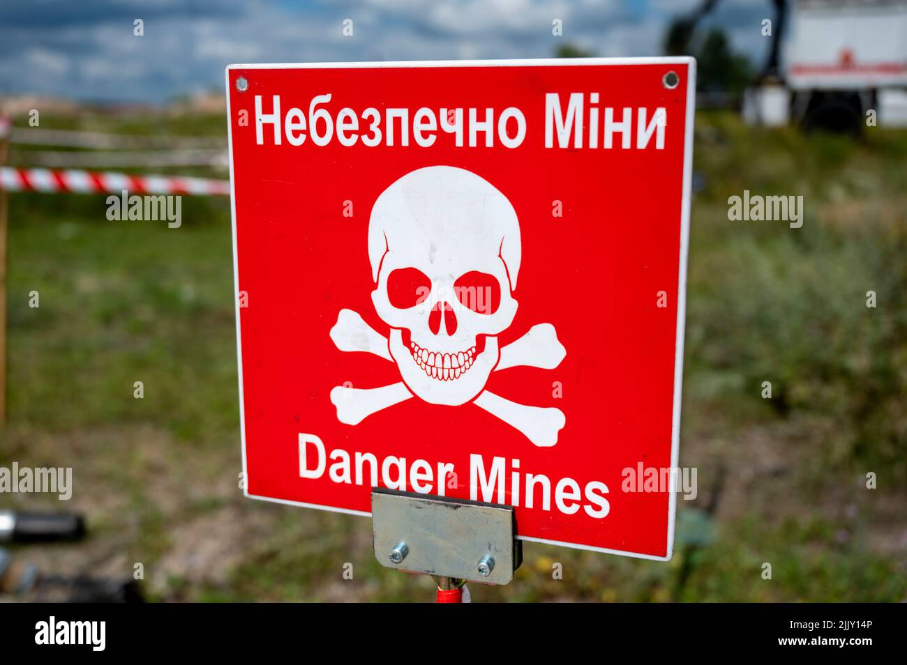 Hostomel, Ukraine. 25th July, 2022. On the grounds of Antonov Airport is a training area for the removal of mines and explosive ordnance. On the edge there is a warning sign with the inscription 'Danger Mines'. Credit: Christophe Gateau/dpa/Alamy Live News Stock Photo