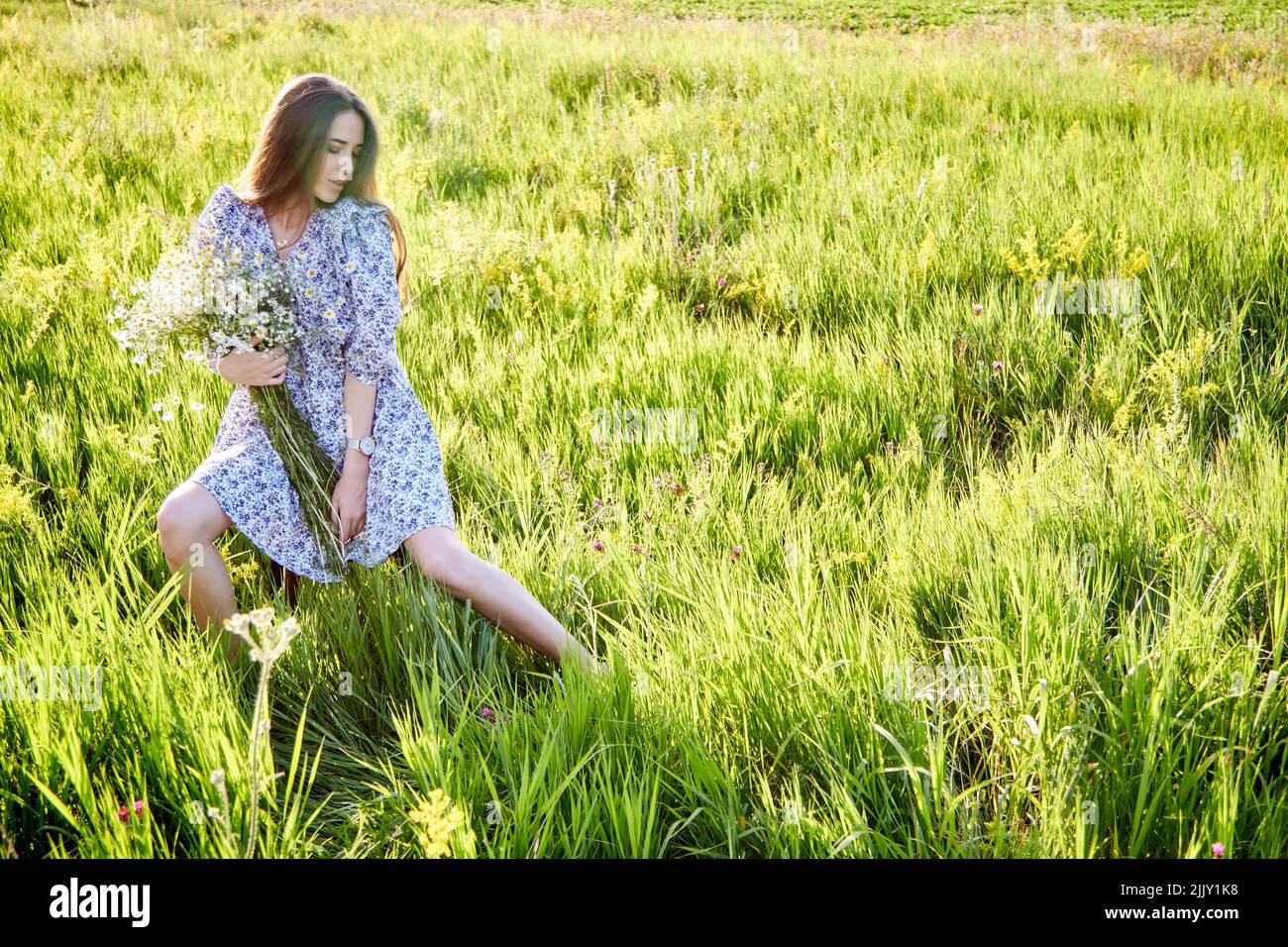 young beautiful girl with a bouquet of flowers in nature Stock Photo ...