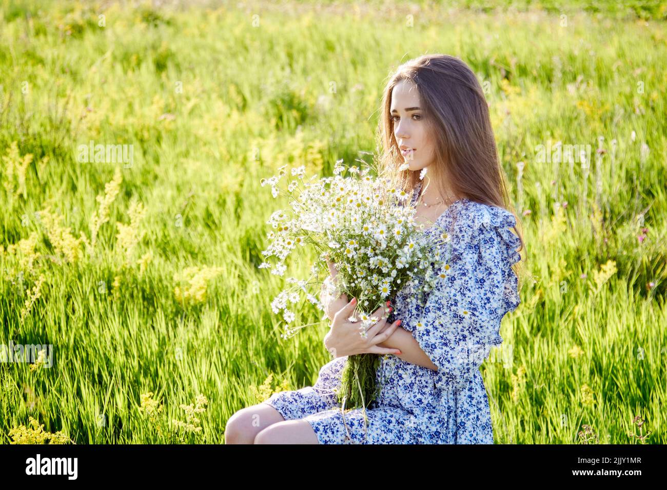 young beautiful girl with a bouquet of flowers in nature Stock Photo ...