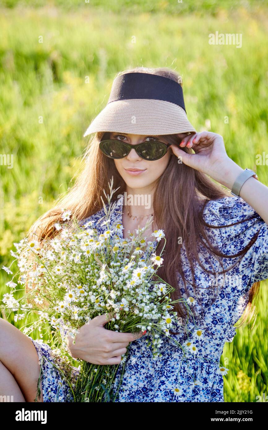 young beautiful girl with a bouquet of flowers in nature Stock Photo ...