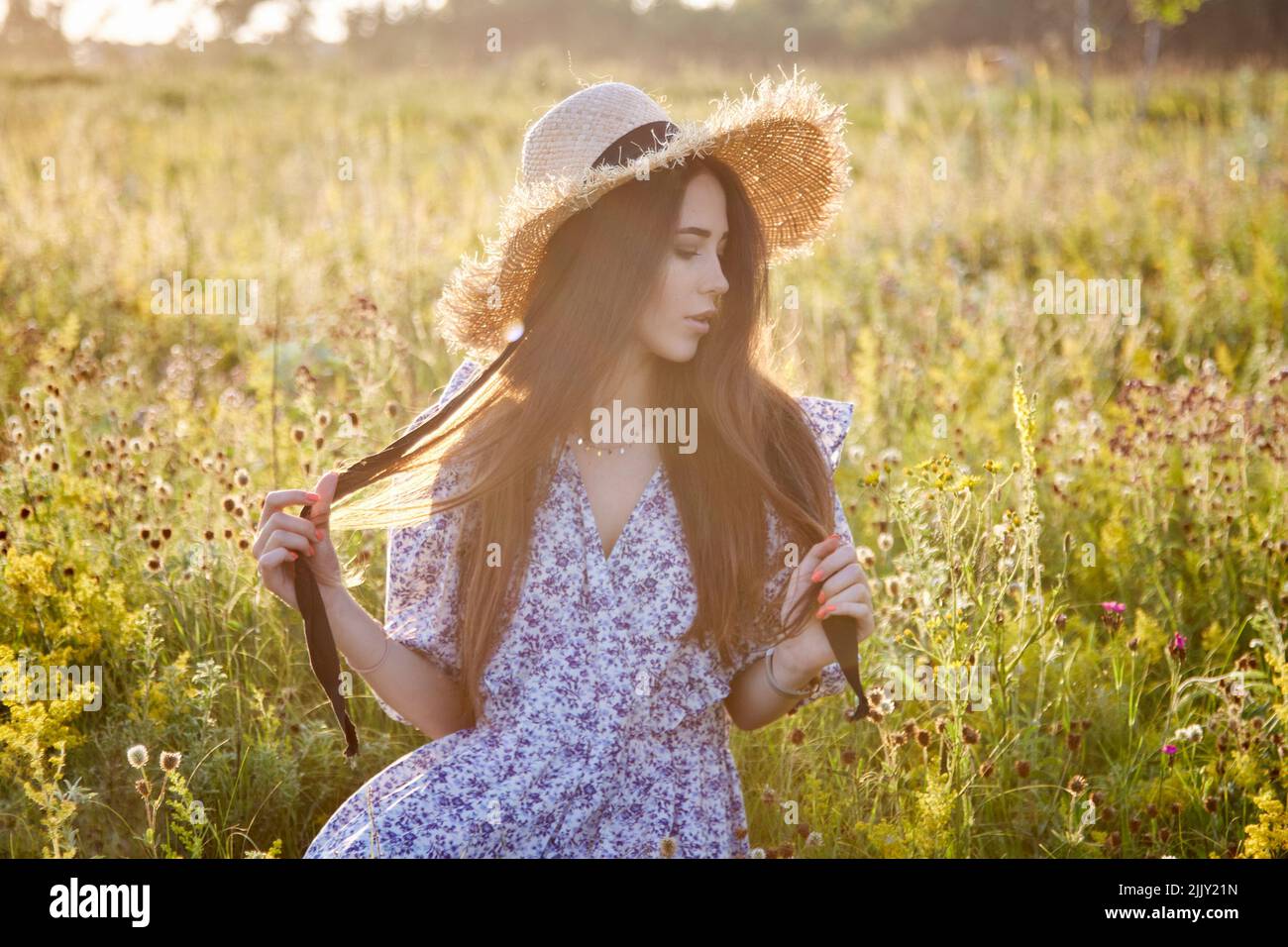 beautiful young girl with a straw hat in nature Stock Photo - Alamy