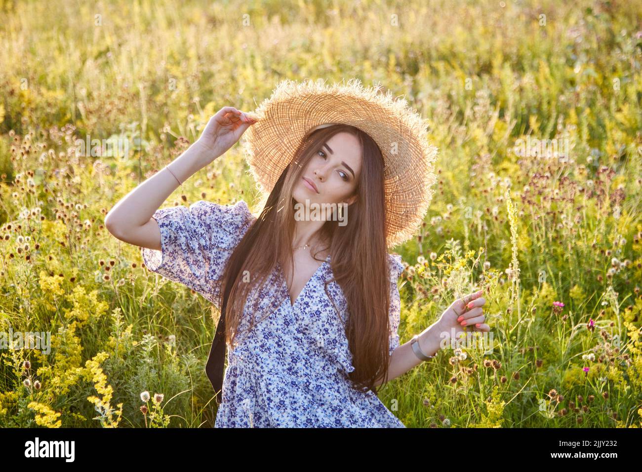 beautiful young girl with a straw hat in nature Stock Photo - Alamy