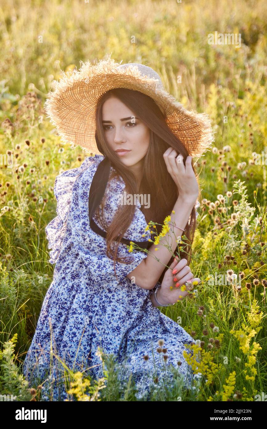 beautiful young girl with a straw hat in nature Stock Photo - Alamy
