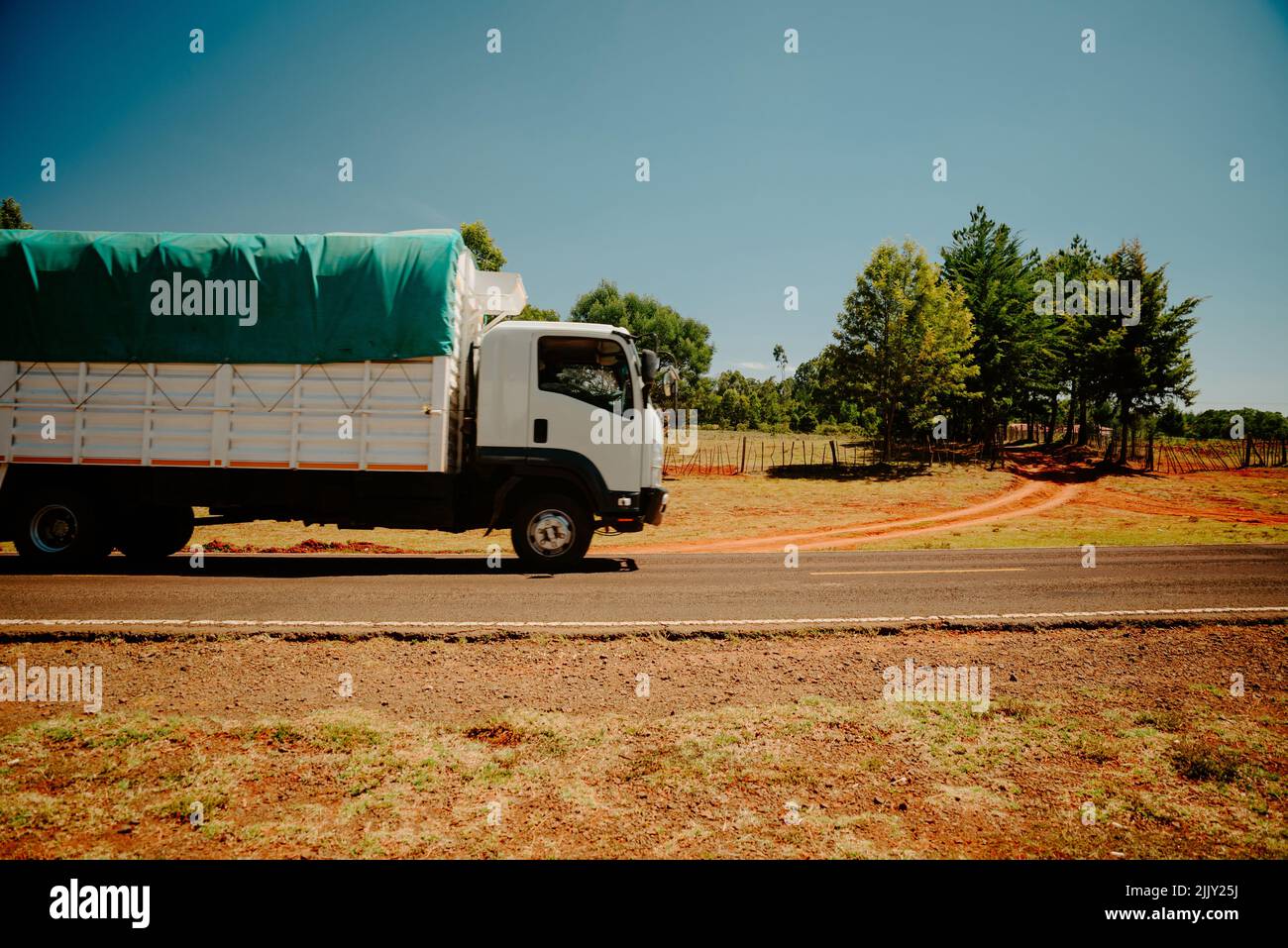 A truck is passing along a road in a simple African country. Kenya, country road outside the town of Eldoret Stock Photo