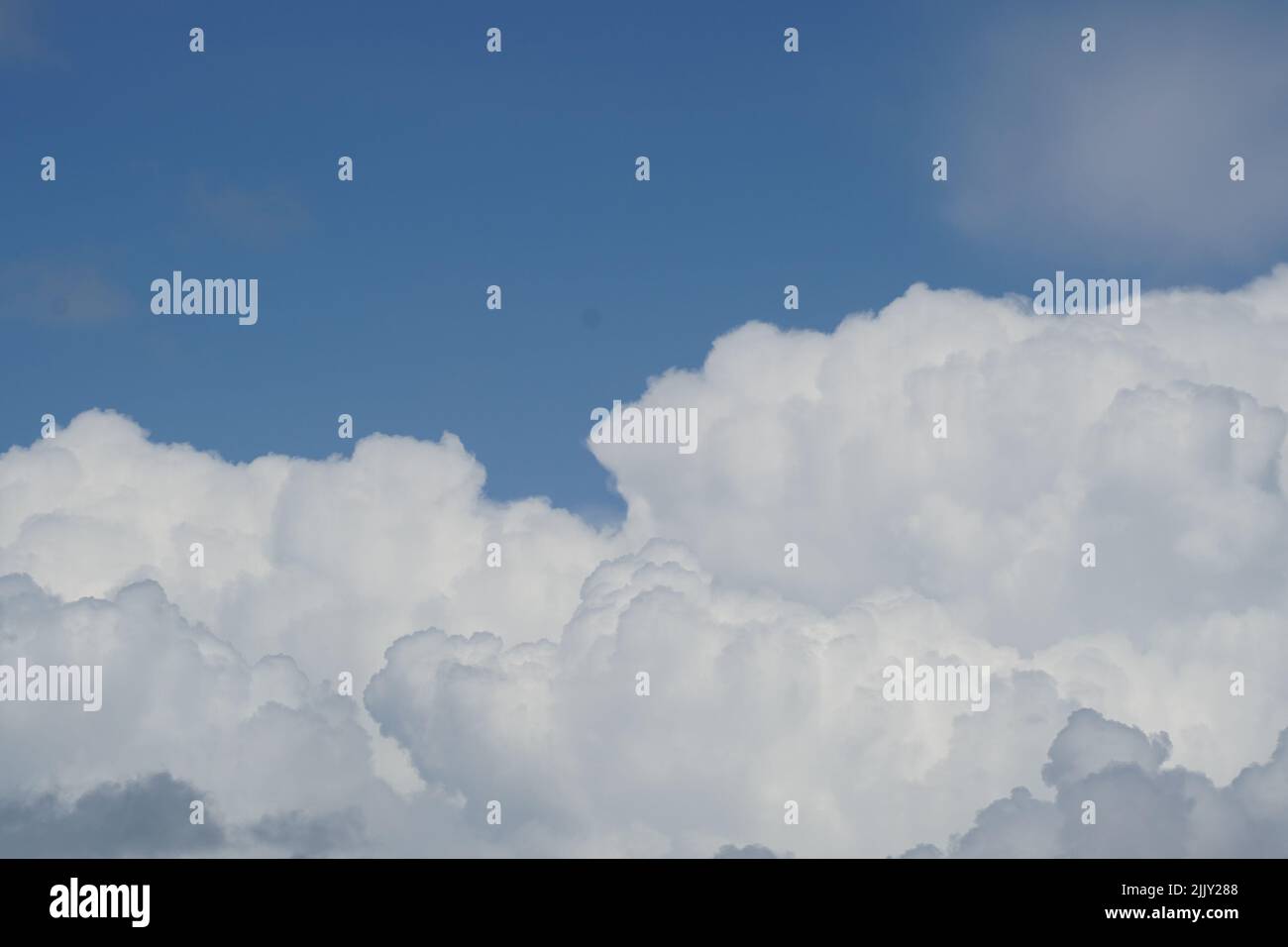 Blue sky background with fluffy clouds Stock Photo