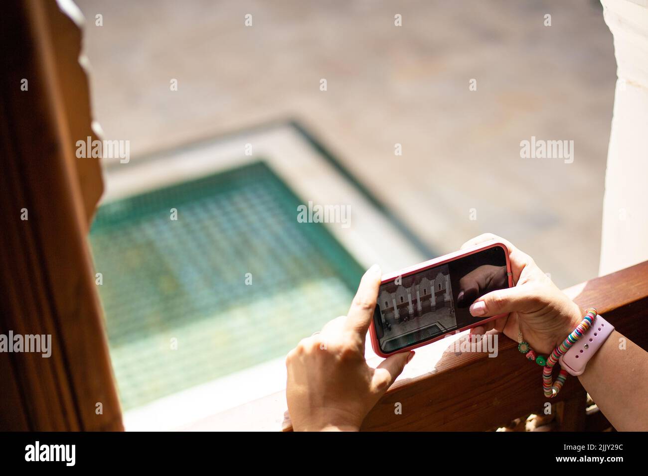 Taking a picture with a smart phone handheld at the edge of a window on a touristic place in Marrakesh, Morocco Stock Photo