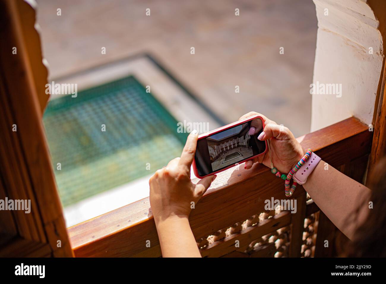 Taking a picture with a smart phone handheld at the edge of a window on a touristic place in Marrakesh, Morocco Stock Photo