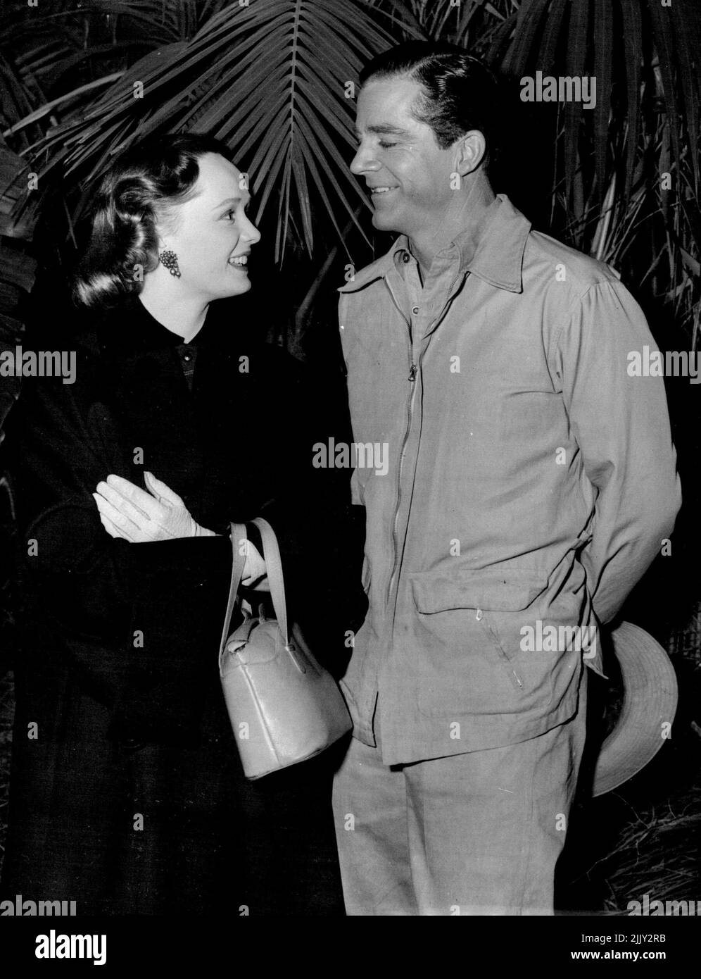 Meeting In 'The Jungle' -- Mary Parker, talented actress sister of Lieutenant-Commander Michael Parker (the Duke of Edinburgh's Personal Equerry), talks with Dana Andrews on the Associated British set as Elstree, Hertfordshire, where he is starring in 'Duel in the Jungle'. Miss Parker, who established a reputation as an actress in Australia, recently arrived in England to continue her career on stage and screen. December 3, 1953. (Photo by Reuterphoto). Stock Photo