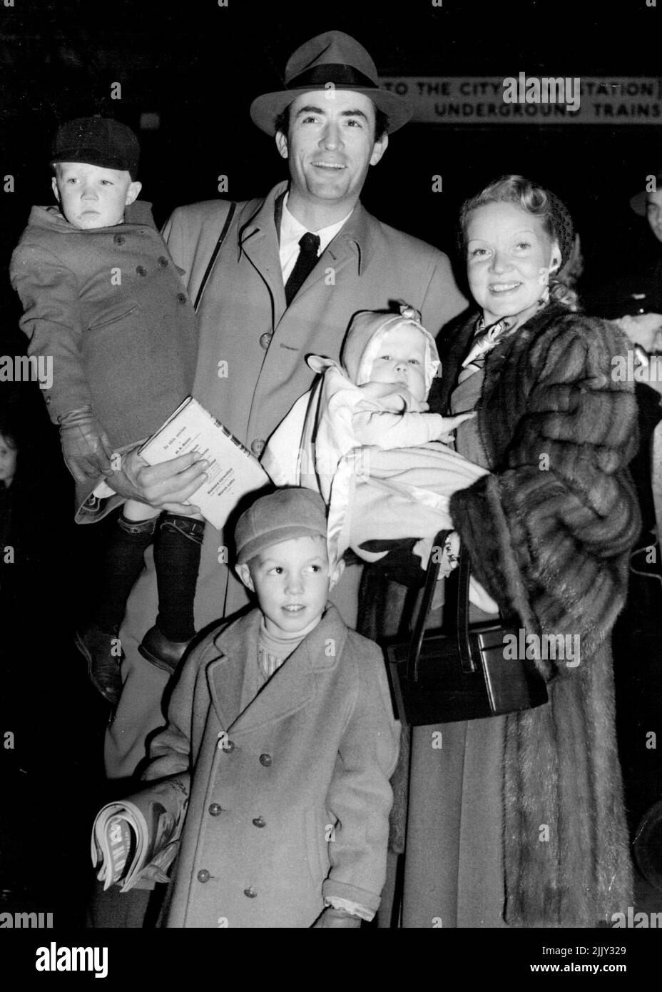 The Pecks In London - Happy-looking family pictured on their arrival at Waterloo station is that of the Packs. They include film actor Gregory Peck, his Finish-born wife Greta, who is holding baby Cary, aged six months, and sons Jonathan, aged 5, and 3-year-old Stephen. January 4, 1950. Stock Photo