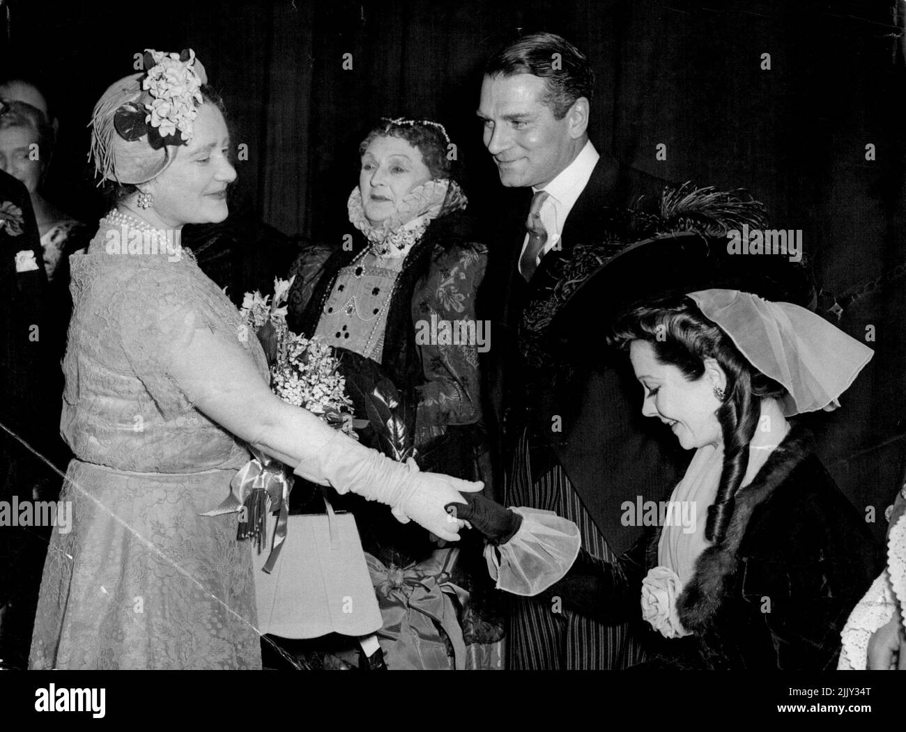 Curtsey For the Queen Mother - Still in costume, actress Vivien Leigh curtsey to Queen Elizabeth, the Queen Mother, at the Variety Club's all-star matinee at Her Majesty's Theatre in the Haymarket, London, to-day (Monday). Next to Vivien Leigh are her husband Sir Laurence Oliveier, and Dame Sybil Thornduke. The matinee commemorated three anniversaries - the fiftieth year since the founding of the Royal Academy of Dramatic Art; Dame Sybil's golden jubilee on the stage; and the birth centanary of Sir Herbert Beerbohm Tree, founder of the PADA. May 31, 1954. (Photo by Reuterphoto). Stock Photo