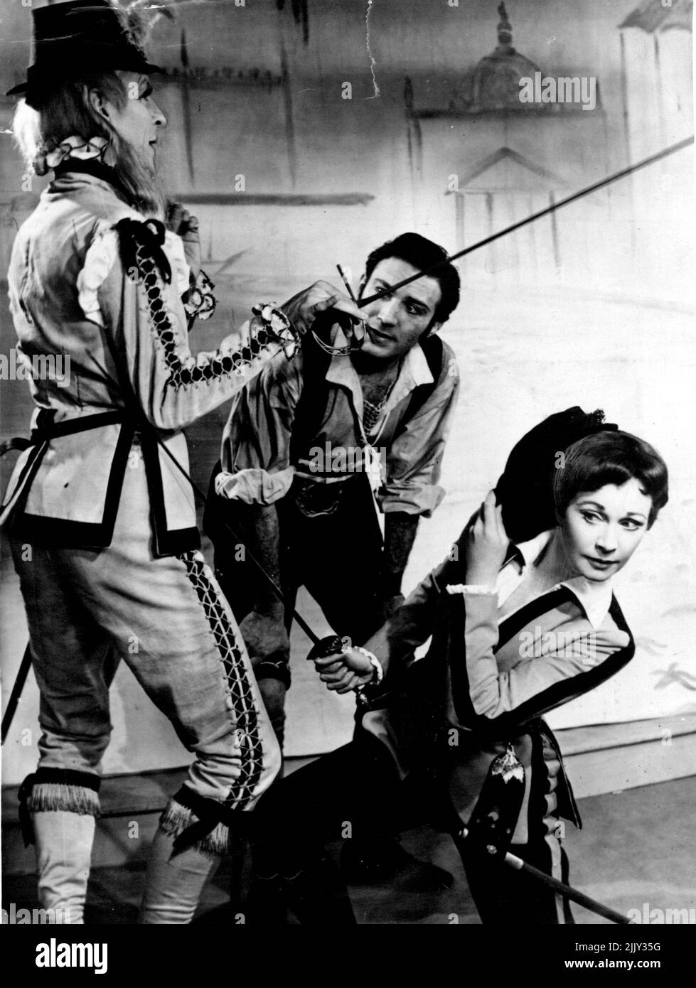 Viola (Vivien Leigh) evaes a thrust by Sir Andrew Aguechek (Michael Denison), left, while Fabin (Lee Montague) looks on during a rehearsal of 'Twelfth Night' at Stratford. Sir Laurence Olivier and his wife, Vivien Leigh, are producing the pay for the 96th Shakespeare Memorial Festival. April 23, 1955. Stock Photo