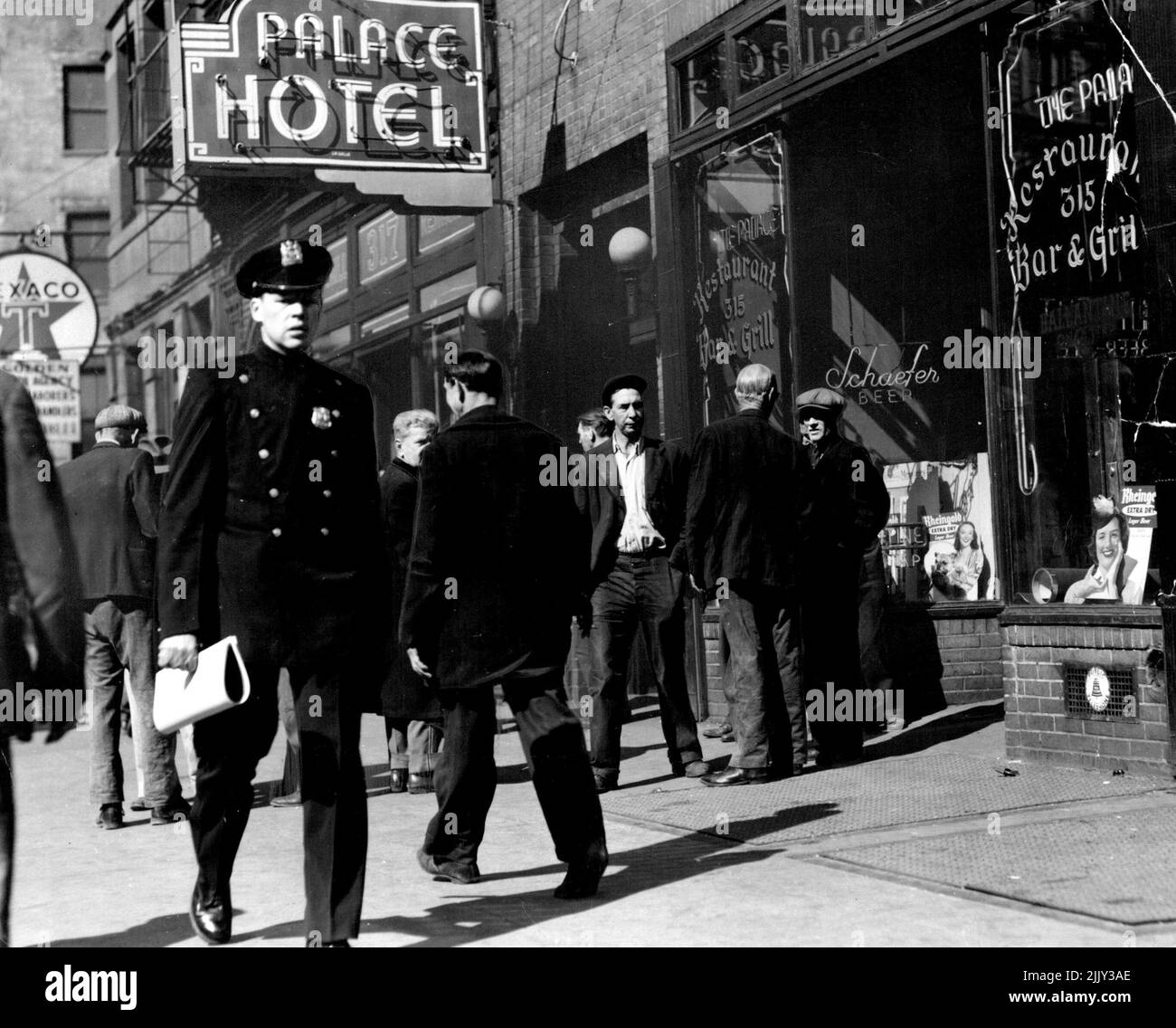 The Bowery cop is the only smart man in this part of New York. He could arrest a man every minute of the day. But he interferes only if they fight. He is inured to the atmosphere of drink and degradation. April 1, 1949. (Photo by Howard Byrne, Camera Press). Stock Photo