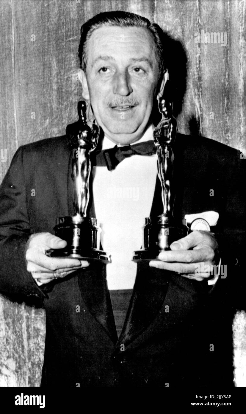 Walt Disney Wins 24th Oscar - Walt Disney, who has won 22 Oscars previously, holds the two he accepted last night at the annual Academy Awards presentations. As Disney waked off with his second golden statuette master of ceremonies Bob Hope quipped that he noticed the famed carton and nature film creator had arrived at the theater in a truck. The Oscars weigh seven pounds each. Disney won for best special effects and art direction in '20,000 Leagues Under the Sea.' March 31, 1955. (Photo by AP Wirephoto). Stock Photo