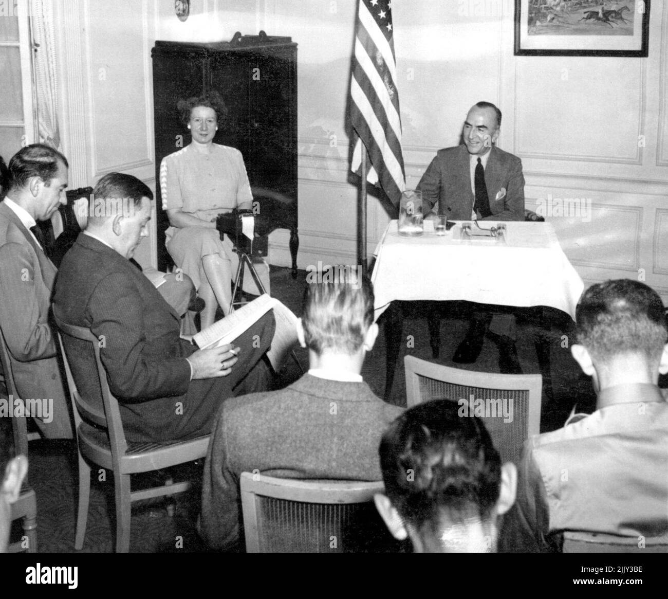 Rickenbaker Holds Press Conference -- Capt. Eddie Rickenbacker (Right Background), just returned from a 55,000-mile inspection tour of War Zones, reports to newspapermen at a press conference in his office in New York, August 17. He said that at the present rate of progress 'Germany Will Not Even Crack before the fall of 1944 at the best,' and stated that 'Only A Miracle Can Bring Victory Sooner'. August 17, 1943. (Photo by Associated ress Photo). Stock Photo