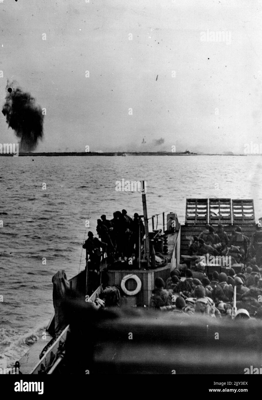 lcheren At West Kapelle -- Explosion and fire ashore after Typhoon attack, as landing craft olose in. The final phase of the battle to free the approaches to the Belgium port of Antwerp began Nov.1; When Royal Marine Commandos landed at dawn at West Kapelle., The Western most point of the island of Walcheren. By dusk the town had been captured and a bridgehead 3,000 yards long to the south had been established. From this bridgehead the Commandos pushed north and south the next day., along the dyke beside the seato Domburg and Zoutelade. January 01, 1945. (Photo by British Official Photograph). Stock Photo