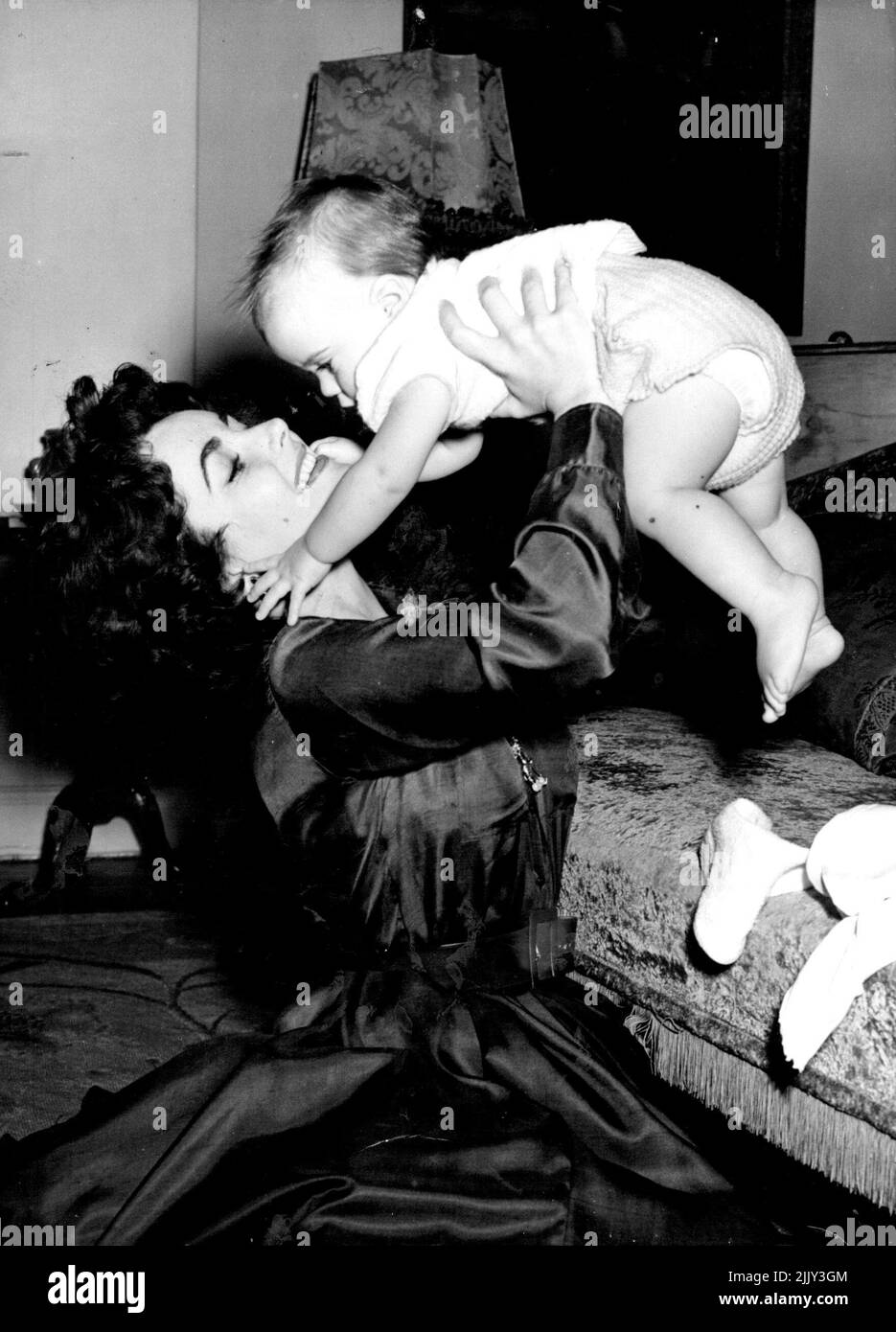 o you expect him to be a well-dressed man-about-town like his famous father? Film star Elizabeth Taylor and Wilding Junior have a Romp together at their London home in Grosvenor square before going off to see young Michael's grand - parents, the wilding family is in Britain especially to show their son to Wilding's parents. Flying: Film star Elizabeth Taylor and her young son Michael Wilding who are in England prior to visiting the baby's grandparents in Copenhagen. Australian nurse Yvonne Lang was in charge of the baby during the air trip yesterday. September 19, 1953. (Photo by Paul Popper). Stock Photo