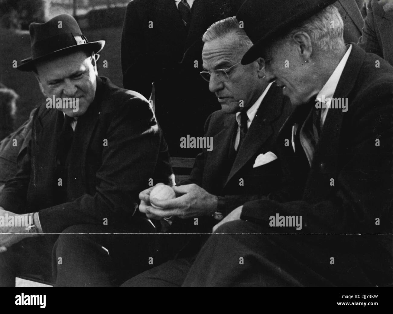 Non-Playing Davis Cup captains, Gerald Patterson (Australia) and Walter Pate (United States) discuss with Sir Norman Brookes, the brand of Tennis ball to be used in the challenge round. May 30, 1947. Stock Photo