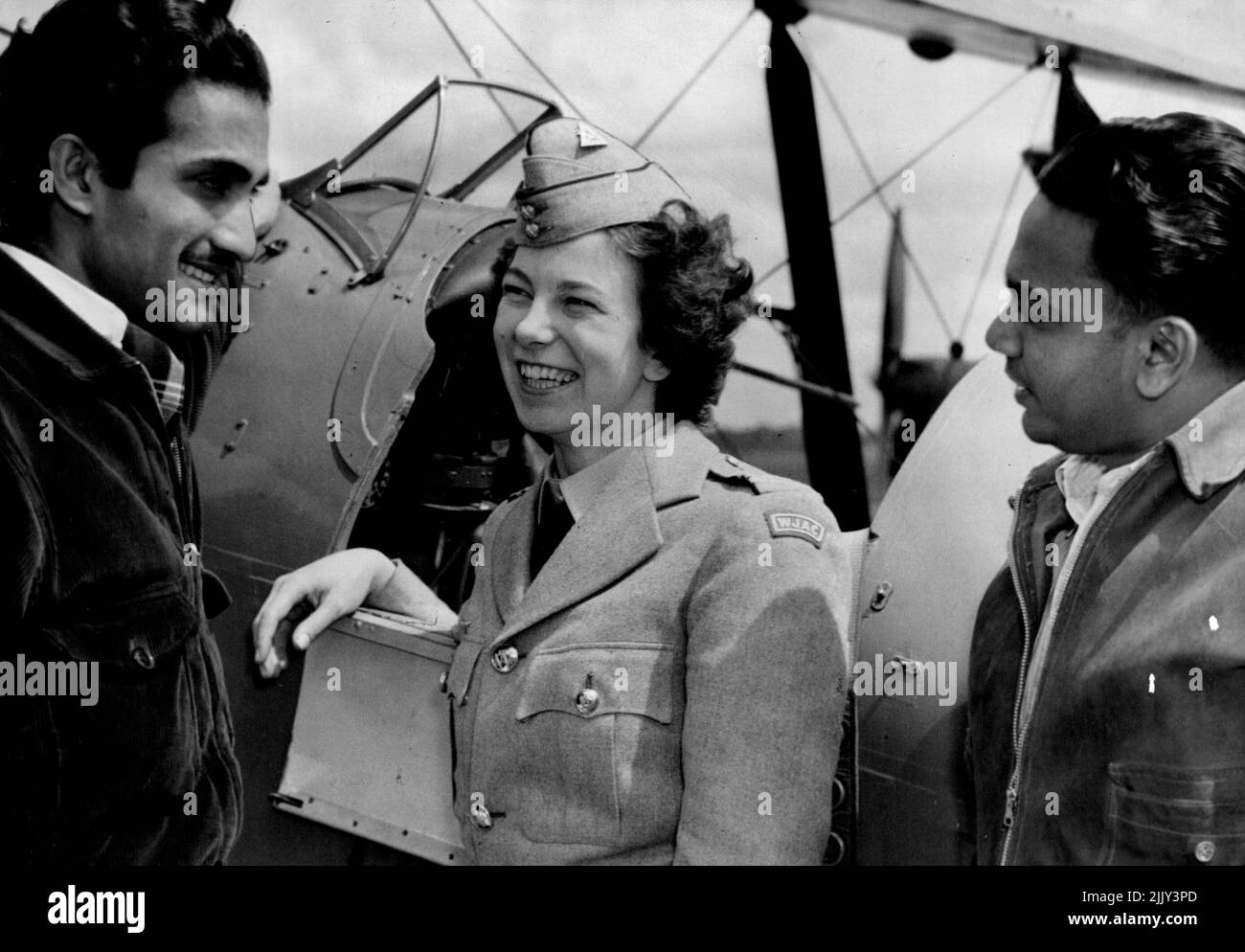 England's perfect air girl, Miss Doreen Pennell, talking to two Ceylonese men who are training for their commercial pilots license with the Royal Aero Club. She met them whilst visiting the aero club at Banks town this morning. March 15, 1950. (Photo by Kenneth Charles Redshaw/Fairfax Media). Stock Photo