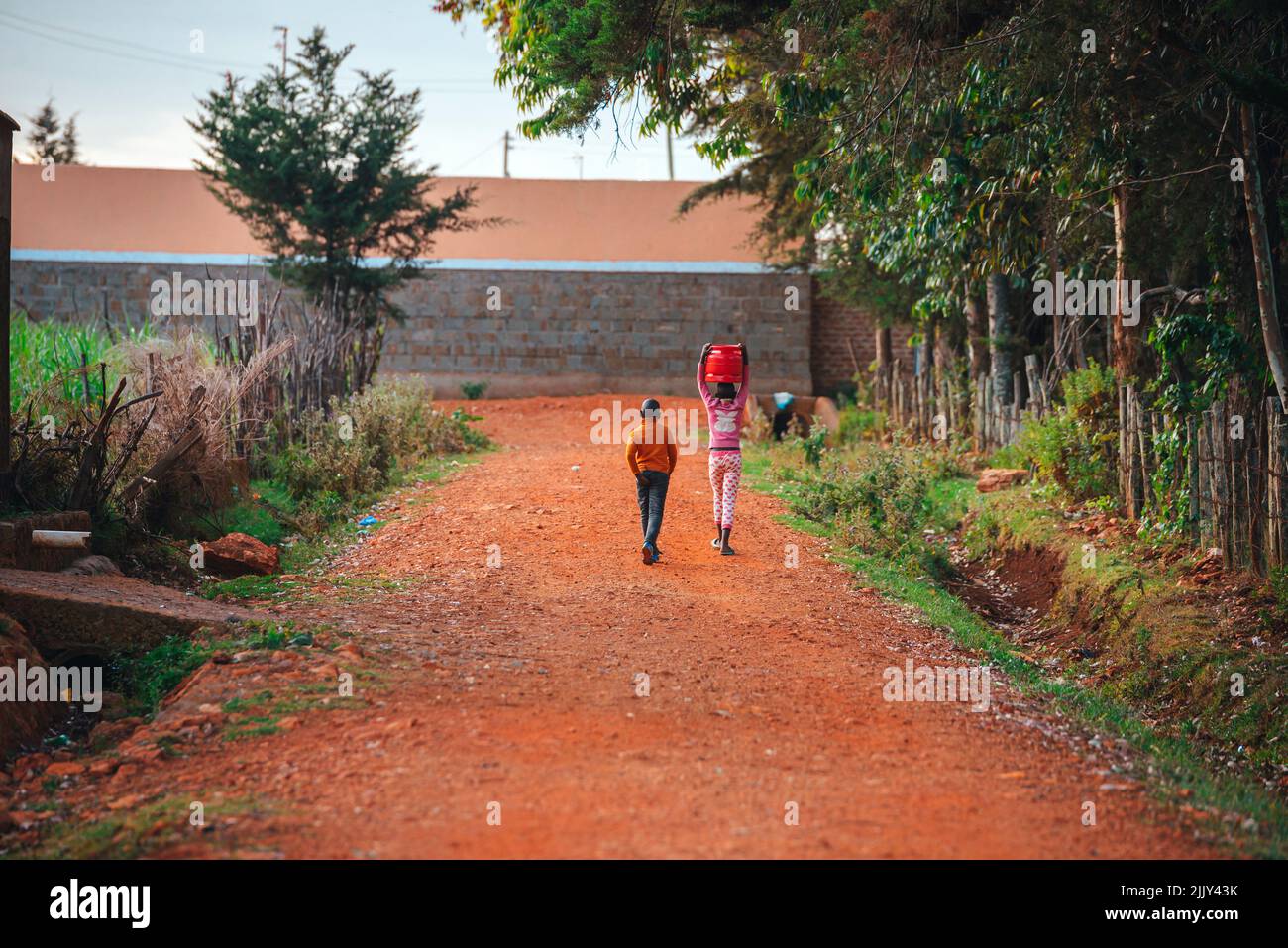 The hard work and life of children in Africa. two small children walking on a road in Kenya. A challenging childhood for young people in Africa Stock Photo