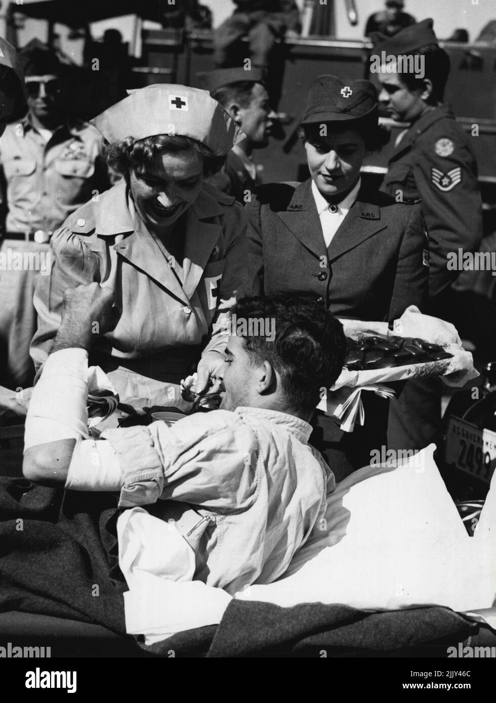 Air Bulletin, No. 6, Vol. 1 -- Red Cross Volunteers aid wounded, an American Soldier, wounded while fighting with United Nations force ***** is served refreshments by American Red Cross Volunteers. April 10, 1951. (Photo by United States Information Service). Stock Photo