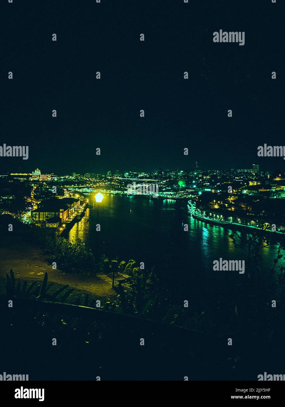 An aerial shot of a river flowing through a city tinted green Stock ...