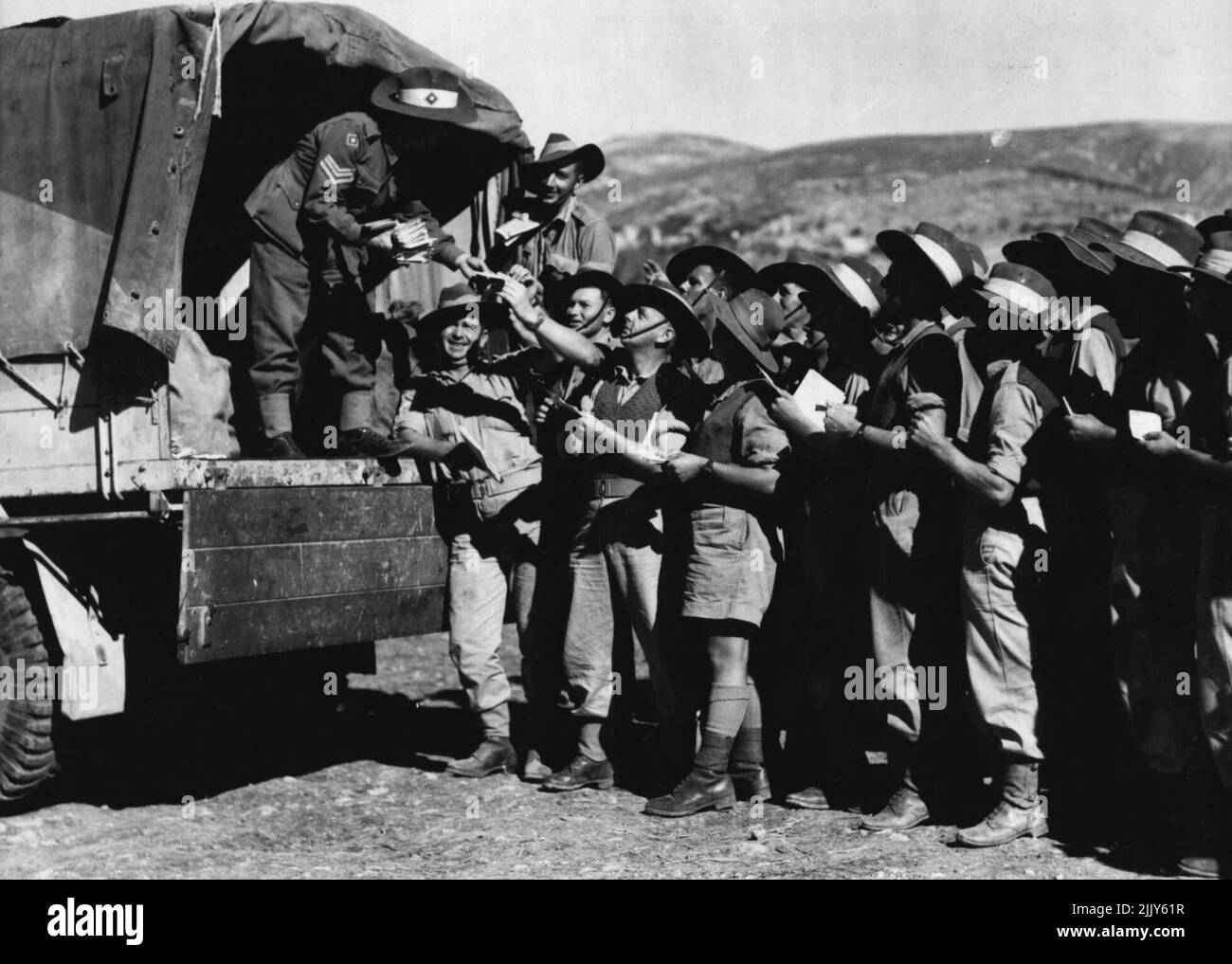 At last! How many emotions on these faces? -- Only one when mail is being handed out. Scene at an Australian field post office, in the Middle East. January 29, 1942. (Photo by A.I.F. Photograph). Stock Photo