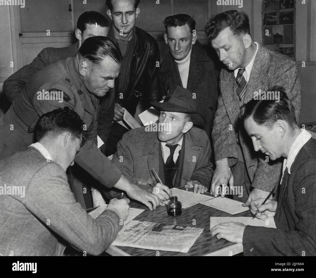 Ready To Serve: Major H.L. Hartnett, Recruiting Officer for Eastern Command, advises John Graeme, 24 (in hat), of Paddington, and a group of other volunteers. July 27, 1950. Stock Photo