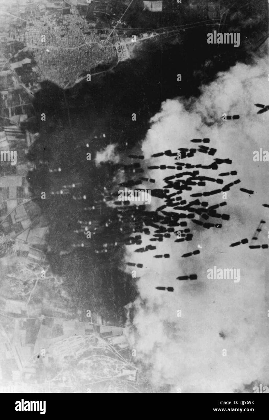 Bombs rain on Monserrato airfield, Sardinia, dropping; past the edge of a Fleecy cloud which screened U.S. Army Air Forces flying Fortresses, more than 100 bombs literally rain down on Monserrato air field near Cagliari in Sardinia. June 28, 1943. (Photo by Associated Press Photo). Stock Photo