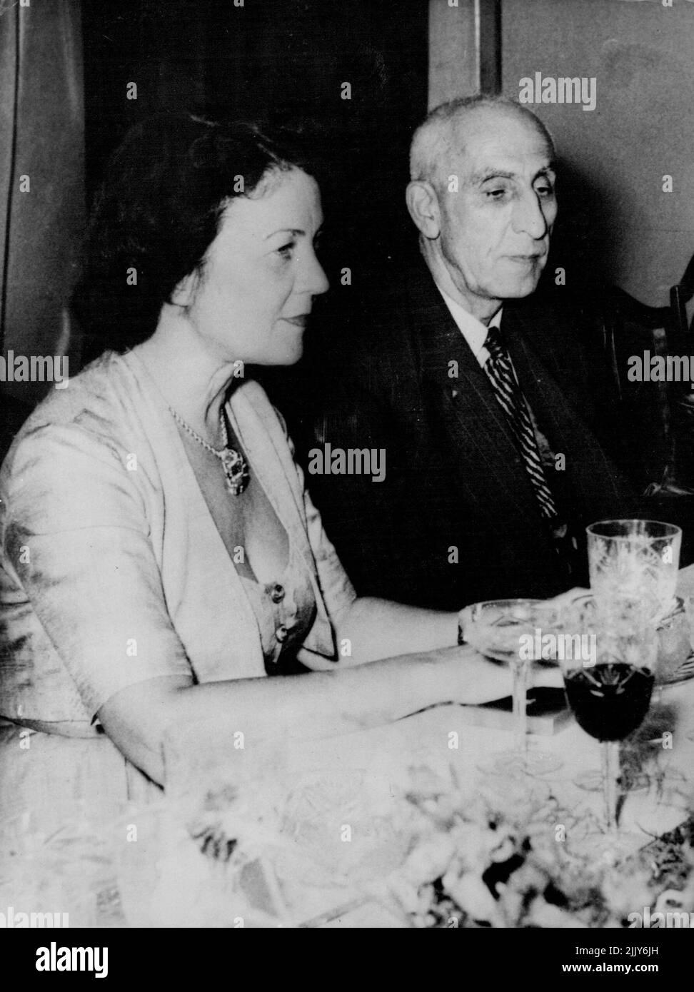 Iranian Premier Dines with Mrs. Harriman -- Dr. Mohammed Mossadeq, the Prime Minister of Iran, chats with Mrs. Averell W. Harriman, wife of president truman's special representative at his home in Tehran, July 24. It will be recalled that Mr. Harriman, informed Sir Francis Shepherd, the British ambassador, of the Persian government's suggestions concerning a basis on which negotiations for settlement of the oil. Dispute might be resumed. July 24. July 27, 1951. (Photo by Associated Press Photo). Stock Photo