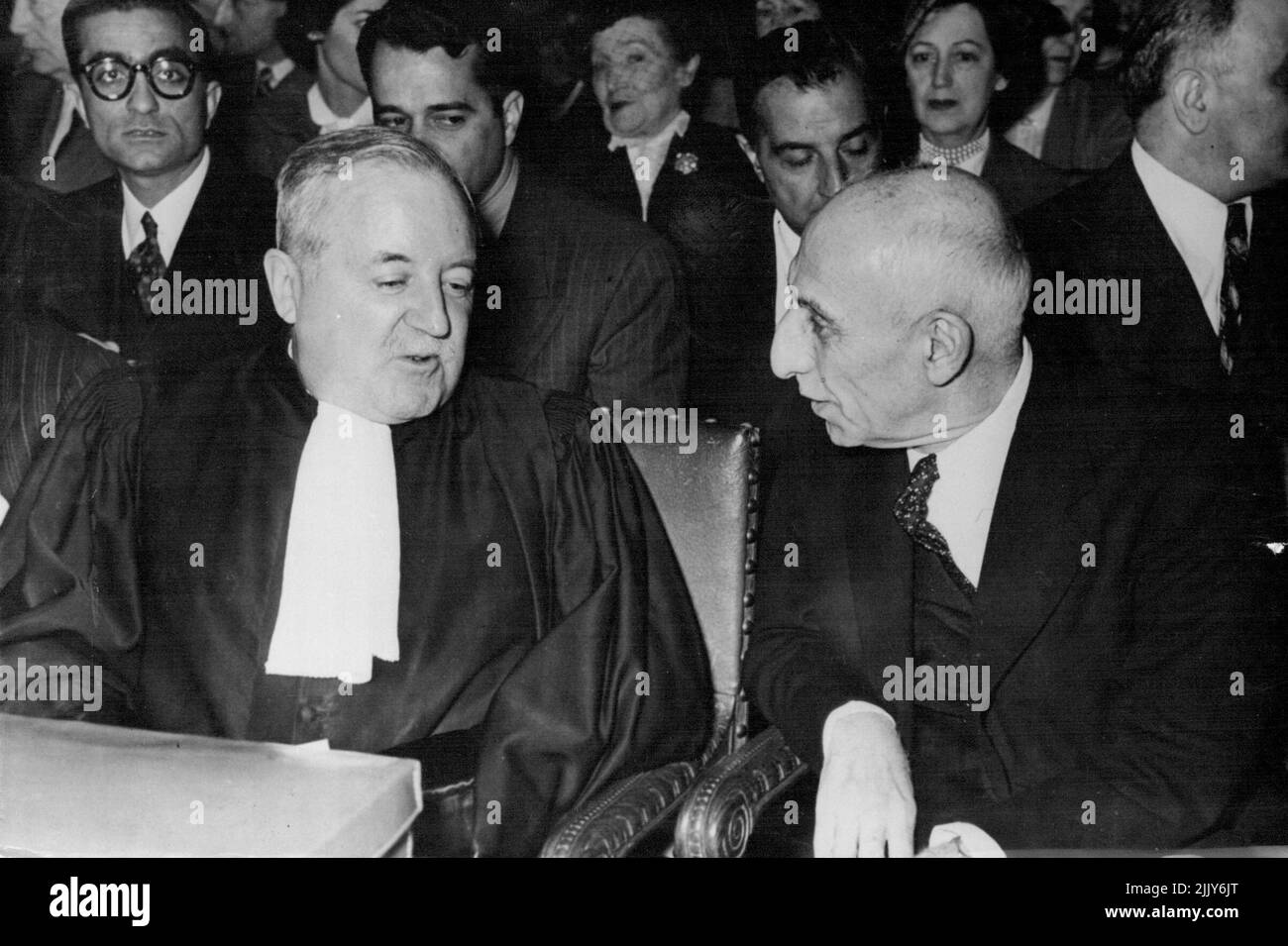 Mossadeq At Hague Court - Dr. Mossadeq (right) talking with Professor Henri Rolin of Belgium, who is pleading the juridical arguments for the Iranian government, before the session was opened at the Hague today. No photographs of the premier were allowed while he was speaking. Dr. Mohammed Mossadeq, the Persian premier, went before the international court of justice at the Hague today June 9 to plead his country's case in the oil dispute with Britain. Although a sick man, he stood without support while speaking. June 9, 1952. (Photo by Associated Press Photo). Stock Photo