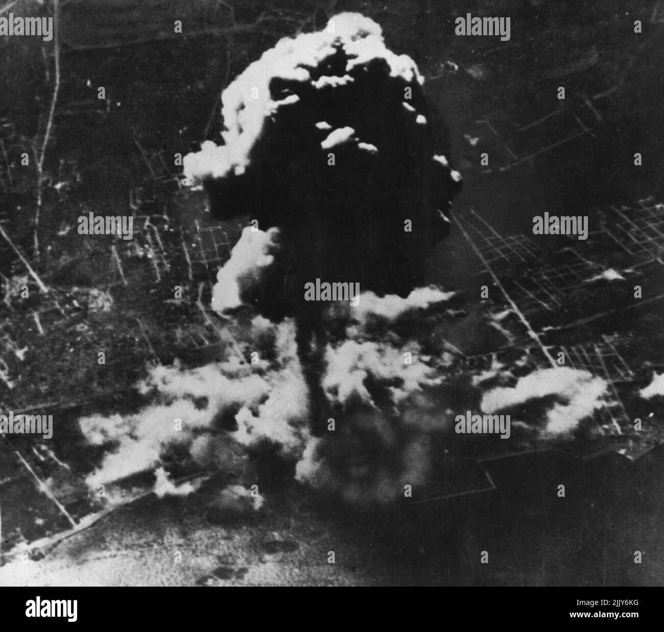 U.S. Bombers Raid Palermo -- Taken during a recent heavy raid by American-manned bonders, this photograph shows a great column of smoke rising as result of a terrific explosion in the dock area at Palermo, Sicily. Reconnaissance photographs taken later revealed that all ships in the vicinity of this tremendous explosion were sunk and a large portion of the centre quay was blown away, two other ships were flung bodily on top of the lower quay. June 03, 1943. (Photo by Department of Air). Stock Photo
