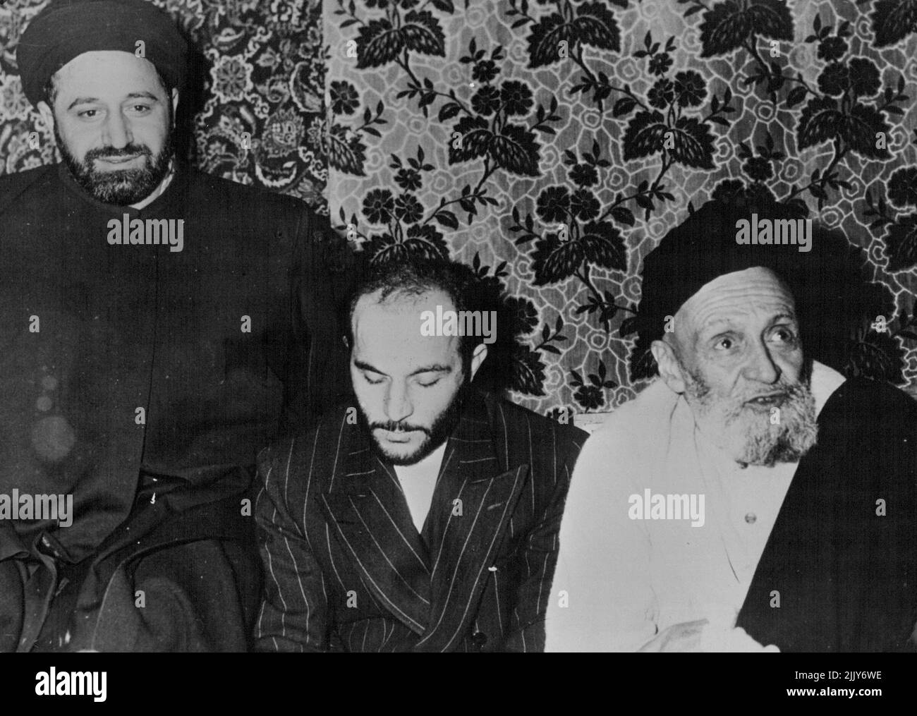 Kashani Receives Released Assassin - From left to right: Qanatabad; Khalil Tahmasbi; Kashani Khalil Tahmasbi, member of the fanatic group Fadain Islam, the man who assassinated General Razmara and started the whole oil crisis in Iran was freed from prison under a special law passed by the Majl's under the influence of Seyyed Abulkasin Kashani, speaker of the Majlis, and religious leader of the extreme Nationalists, who joyfully welcomed his disciple back. With them is Qanatabadi another prominent member who is likely to become Kashani's successor. January 20, 1953. (Photo by Camera Press). Stock Photo