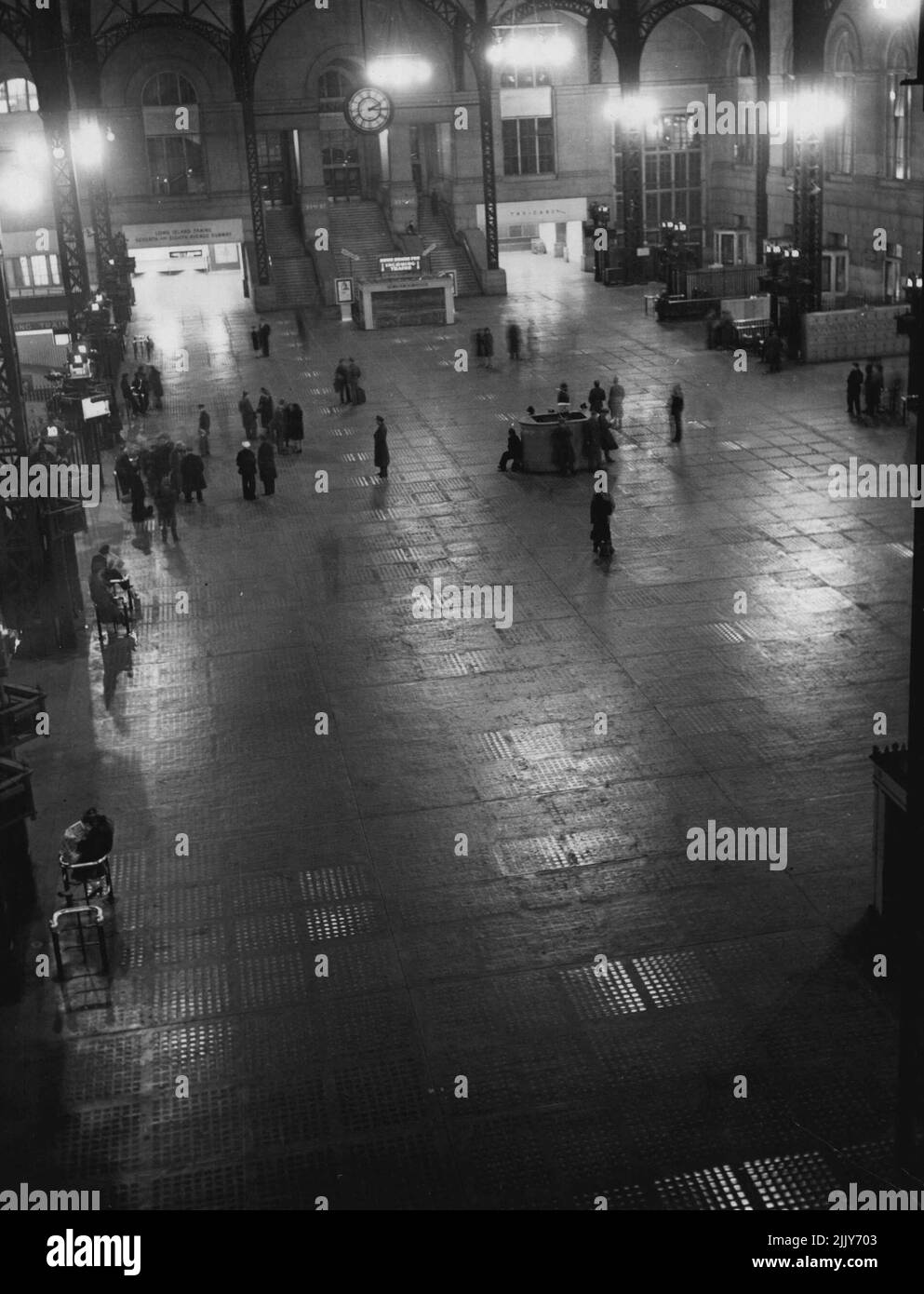 New York Night Life -- The few people on the gate level in Pennsylvania Station at 2:15 a.m. are but a fraction of the terminal's rush hour crowds. The gates, at left and right, lead to the train level, next below. June 20, 1946. (Photo by Wide World Photos). Stock Photo