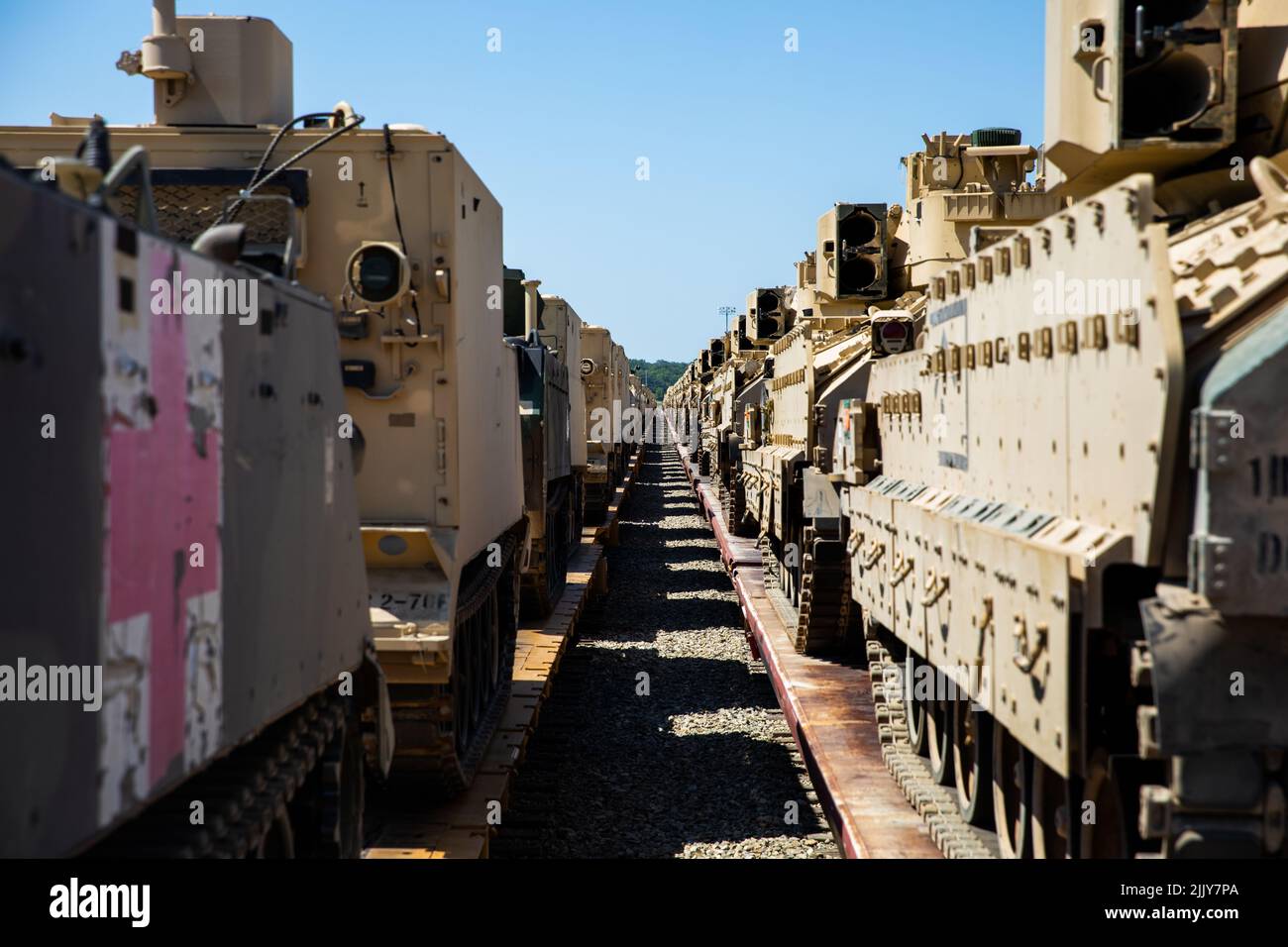 Train cars carrying M2 Bradley Fighting Vehicles alongside High Mobility Multipurpose Wheeled Vehicle’s (HMMWV’s) and an M113 Armored Personnel Carrier are staged prior to transportation to the National Training Center at, Fort Irwin, California, July 24, 2022. All vehicles are staged and inspected several times before being cleared for transportation. (U.S. Army Photo by Pfc. Kenneth Barnet) Stock Photo