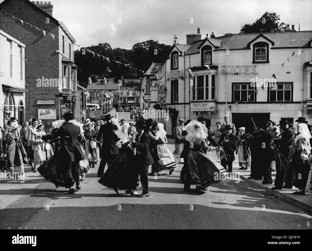 On And On They Danced -- Through the streets of Llangollen, Wales, dance the members of the 'L'Ecole Ventadour' of Tulle, France. They are giving the Townsfolk a ***** of the dancers they will perform ***** the International Eisteddfod which ***** at Llangollen yesterday. July 8, 1954. (Photo by Paul Popper, Paul Popper Ltd.) Stock Photo