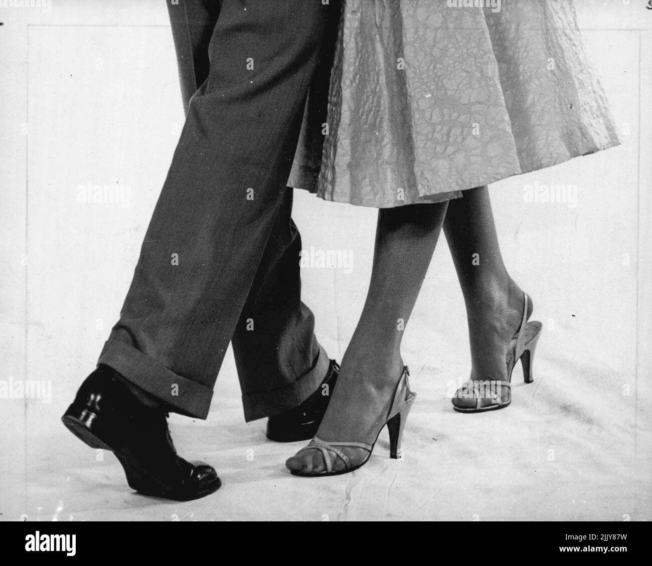 Step Five (slow): Turning to the left now, the man moves his right foot back. The girl moves her left foot forward, turning to the left. March 14, 1955. Stock Photo