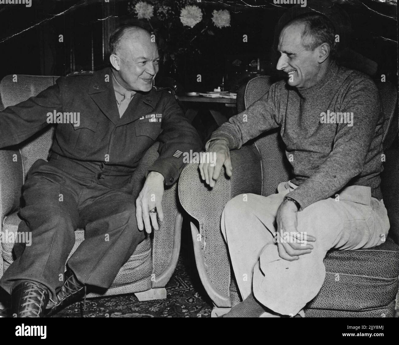 General Dwight D. Eisenhower (left), Allied Supreme Commander conferring with Field-Marshal Sir Bernard Montgomery. C.-in-C., British Forces, at the later's headquarters in Belgium recently. Field-Marshal Montgomery is wearing the sweater and informal dress he usually appears in while on active service. General Eisenhower and General Montgomery photographed at a conference at Headquarters in France during the war. December 30, 1944. (Photo by "U.S: Office Of War Information Picture"). Stock Photo