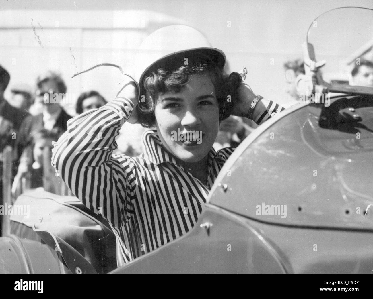 The Name Is Moss -- The bright-eyed girl in the crash helmet is Pat Moss, 20, sister of ace racing driver Stirling Moss, seen getting ready for the ladies' race at Goodwood. But she was unplaced. A crash helmet is Pat Moss constant fashion in have Pat, 20, ***** of ace racing driver Stirling Moss. Here she is getting ready for a ***** race at Goodwood. June 01, 1955. (Photo by Daily Mirror). Stock Photo