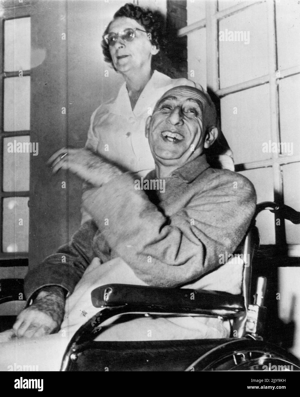 Happy Interlude - Premier Mohammed Mossadegh of Iran enjoys a laugh as he talks with newsmen during a photographic conference at New York Hospital here today. Nurse Ruth Meacham stands behind his wheel chair. The Iranian leader is in New York to give his side of the Iranian-British oil refinery dispute before the United Nations Security Council. He has been in ill-health for some time and is residing at the hospital rather than at a hotel. October 12, 1951. (Photo by AP Wirephoto). Stock Photo