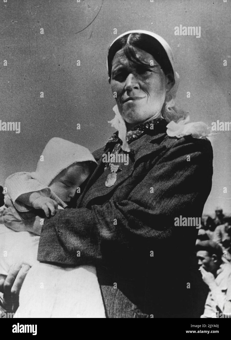 Women In The Soviet Union -- Mother Heroine -- Kalbuby Tastanbekova, a member of a collective farm in Kazakhstan, gave birth to her tenth child, a girl, in the first days of the war. She named her daughter Jenis (Victoria in the Kazakh language). The mother of ten children was called to, the Kremlin in Moscow and was presented with the Order of Mother Heroine. Kalbuby Tastanbekova is shown above with her baby daughter. June 11, 1948. (Photo by Pictorial Press). Stock Photo