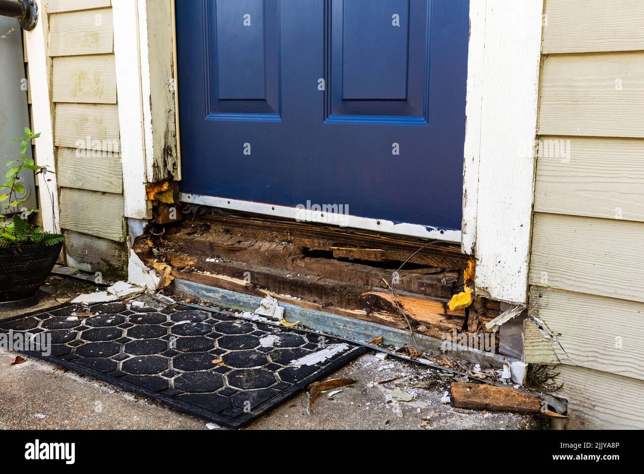 Door on house with extensive damage to wood framing Stock Photo