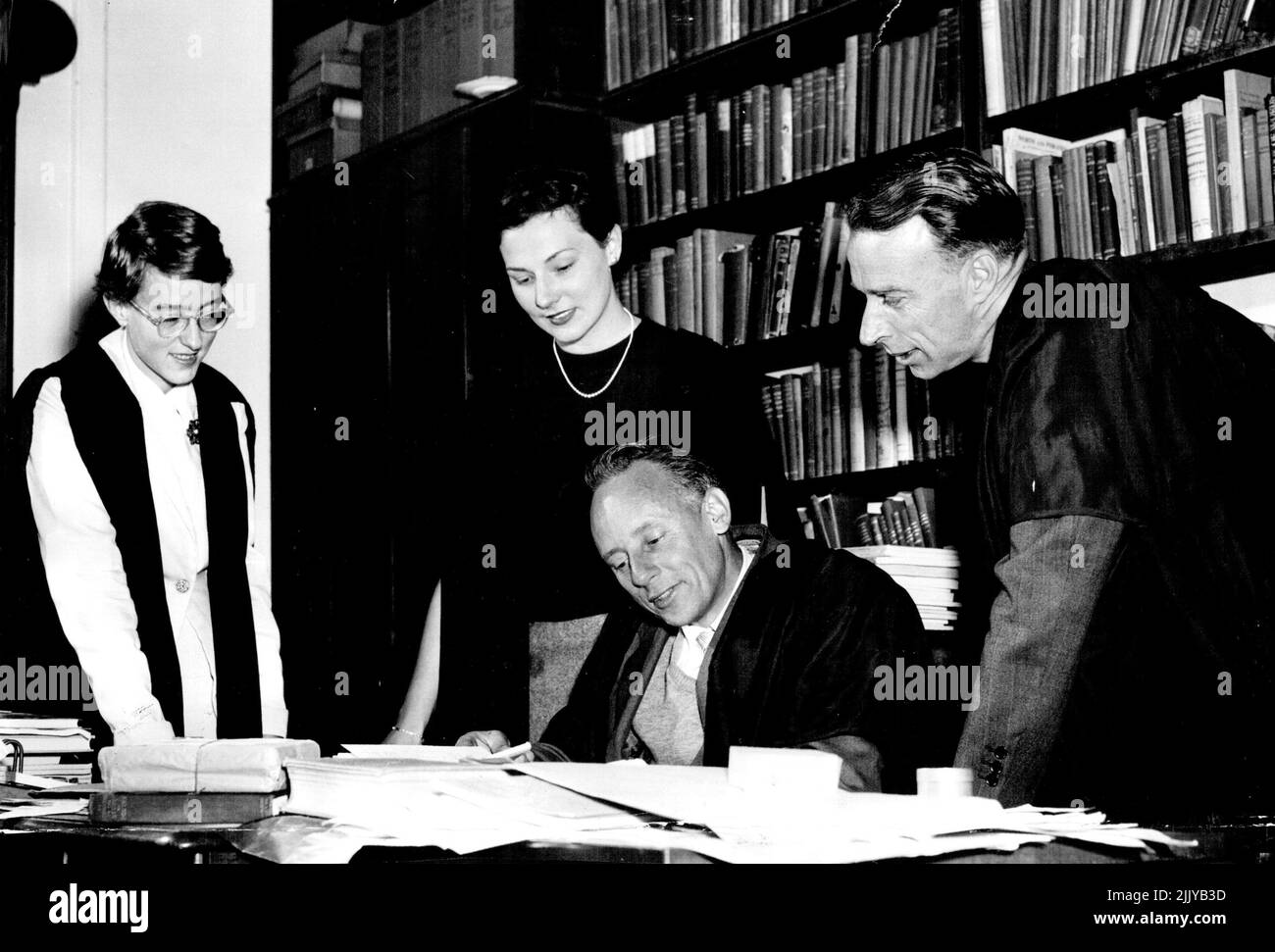 Teaching follows Alison Jones and Jennifer Davidson smile with professors Mitchell and Milgate (right) at the latest quip on accents. November 4, 1955. Stock Photo