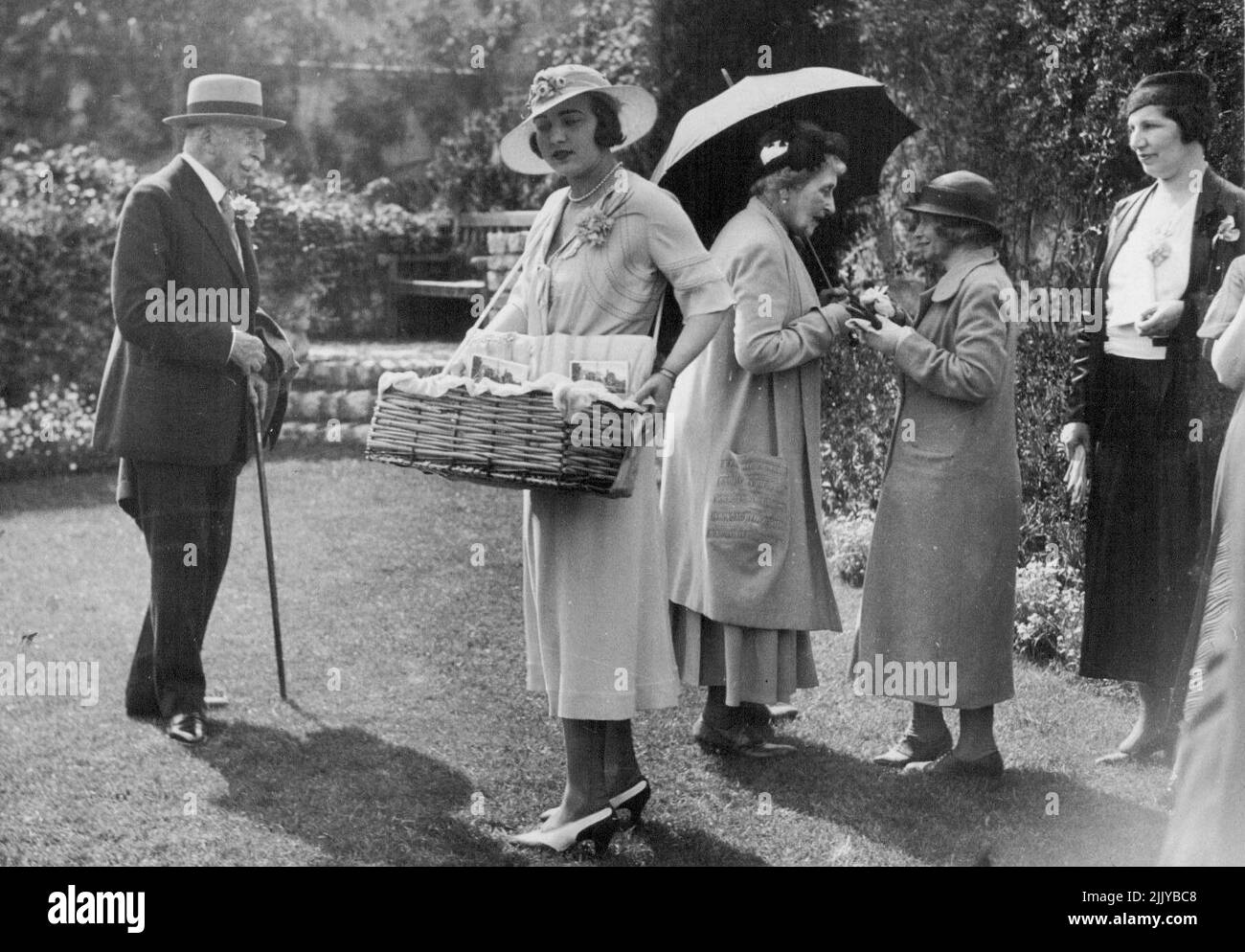 Princess Ingrid Sells Lavender Bags. -- Princess Ingrid selling buttonholes. The Duke is also seen and Princess Louise, talking to a visitor. The Duke of Connaught on Easter Sunday, opened to the public, the beautiful gardens of his vills 'Les Bruyeres' at St. Jean, Cap Ferrat. Princess Ingrid accompanied by the Princess Louise, the Duke's sister, was busy selling bags of lavender in aid of the Queen Victoria Hospital at Mont Boron. May 29, 1933. (Photo by Central News). Stock Photo