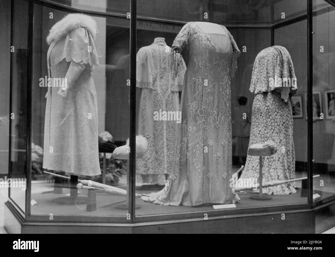 A large case containing four hats, some parasols and dresses worn by