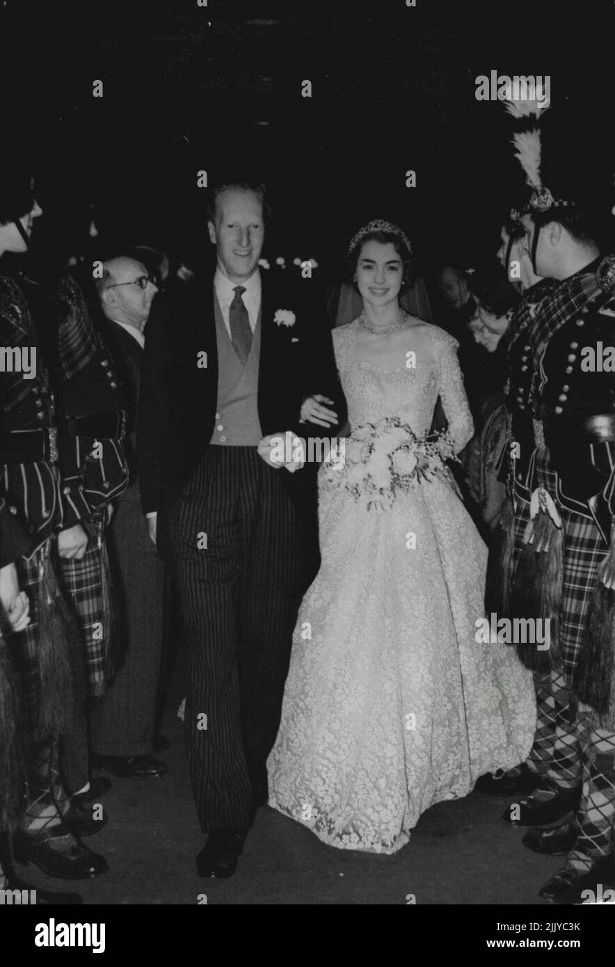 Photo shows: The bride and bridegroom leaving after the ceremony. The guard of honour is composed of pipers of the City of Edinburgh Police force. Royal Guests at Earl of Darlkieth's wedding. The marriage between the 29 years old Earl of Dalkeith, son and heir of the Duke and Duchess of Buccleuch, and Miss Jane McNeill, 22 years old daughter of Mr. John McNeill, Q.C. and Mrs. McNeill, took place at St.Giles Cathedral, Edinburgh, Scotland. Queen Elizabeth with other members of the Royal Family were among the many guests. January 11, 1953. (Photo by Sport And General Press Agency Limited) Stock Photo