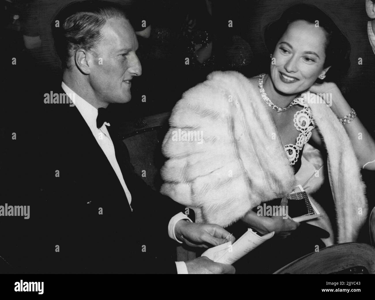 Photo Shows:- Tonight's photograph of the earl of Dalkeith and Merle Oberon at the Theatre. Earl and Film Star at first night Tonight:- The Earl of Dalkeith tonight went with film star Merle Oberon to the Westminster Theatre to see the first night of the new play 'A Priest in the Family' by John Synge and Kieran Tunney. John Synge is a Grandson of the famous Irish Playwright J.M.Synge and is an old friend of the Earl of Dalkeith. The Earl met Merle Oberon recently in Hollywood where he was her guest. 'She is a friend of the family' he said. October 01, 1951. (Photo by Paul Popper) Stock Photo