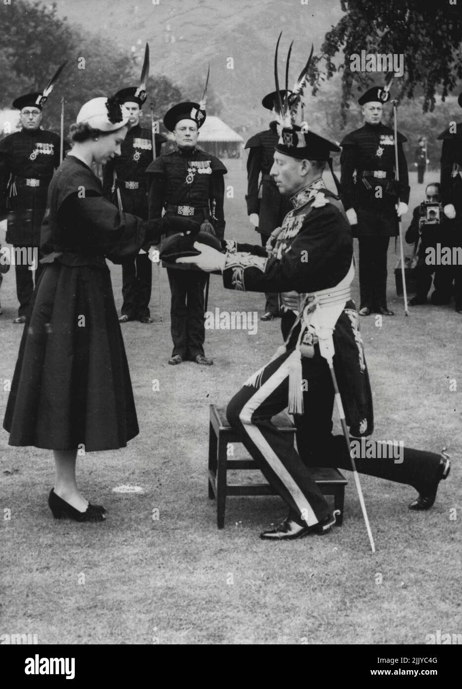 Arrow Brooch for the Queen The Queen receives a reddendo of Arrows in the shape of a brooch from the Duke of Buccleugh, captain of the royal company of Archers, the Queen's bodyguard in Scotland, on June 26. The Queen had just inspected the company in the grounds of the palace of Holyroodhouse, Scotland, where here majesty is staying. June 27, 1952. Stock Photo