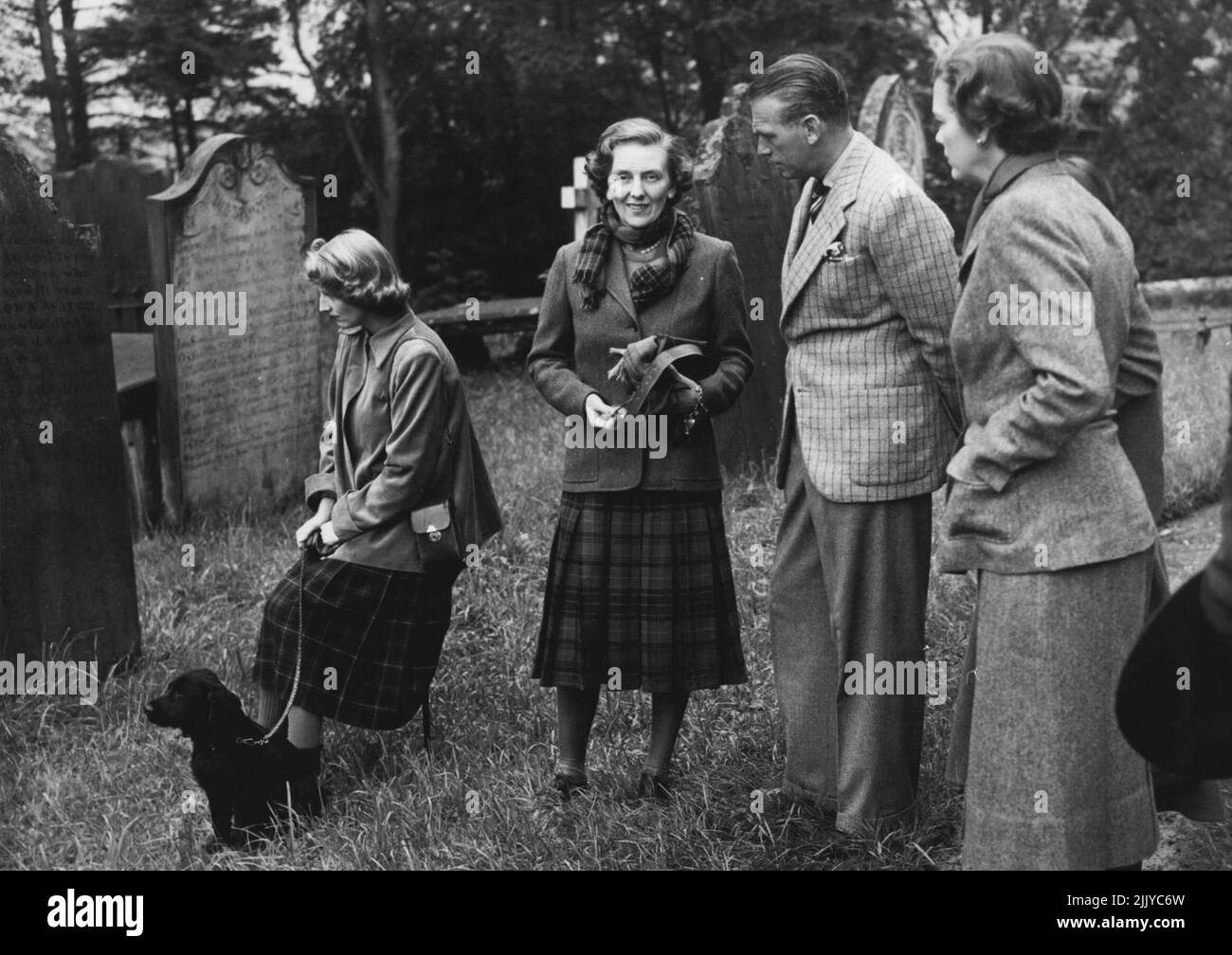 ccleuch; the Duchess of Buccleuch ; Mr Douglas Fairbanks the actor, and (hidden) Mrs Douglas Fairbanks. Gravestones dating from 1415 are decipherable. On right (foreground) is the Baroness Juel of Denmark. The Duke of Buccleuch's Party at Drumlanrig:- The Duke and Duchess of Buccleuch were hosts to Mr and Mrs Douglas Fairbanks, Baron and Barones Juel of Denmark, the Duchess of Northumberland and Mr Douglas Scott, among other at a shooting party at Drumlanrig Castle over the week end. Princess Margaret who was also a guest did not take part in the shoots. August 21, 1950. (Photo by Fox Photos). Stock Photo